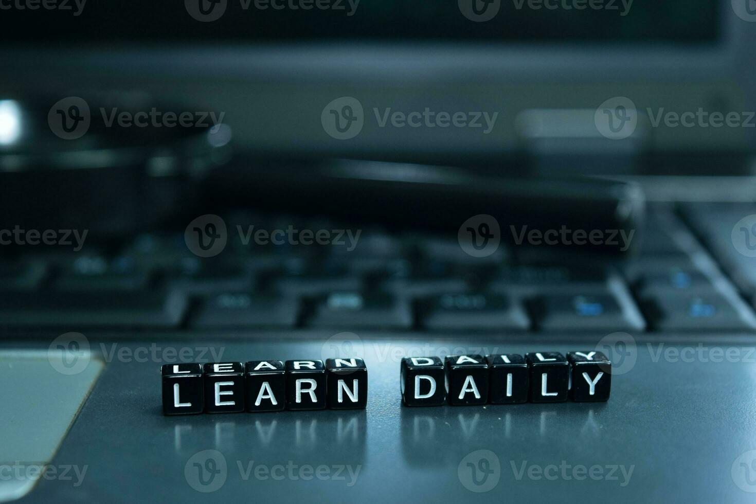 Learn Daily text wooden blocks in laptop background. Business and technology concept photo