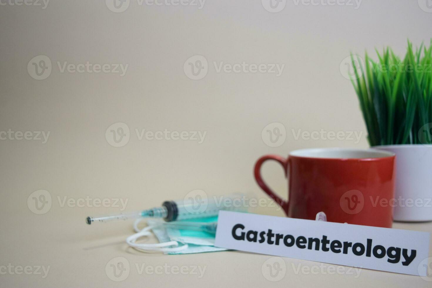 gastroenterología texto, césped maceta, café taza, jeringuilla, y cara verde mascarilla. Cuidados de salud médico y negocio concepto foto
