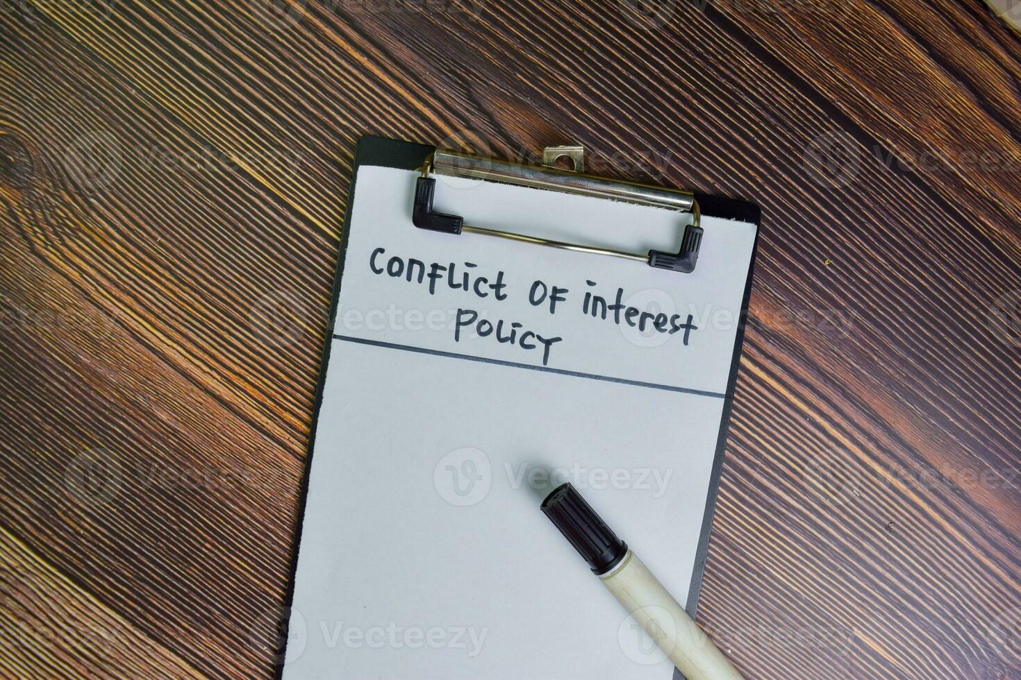 Conflict of Interest write on a paperwork isolated on Wooden Table. photo