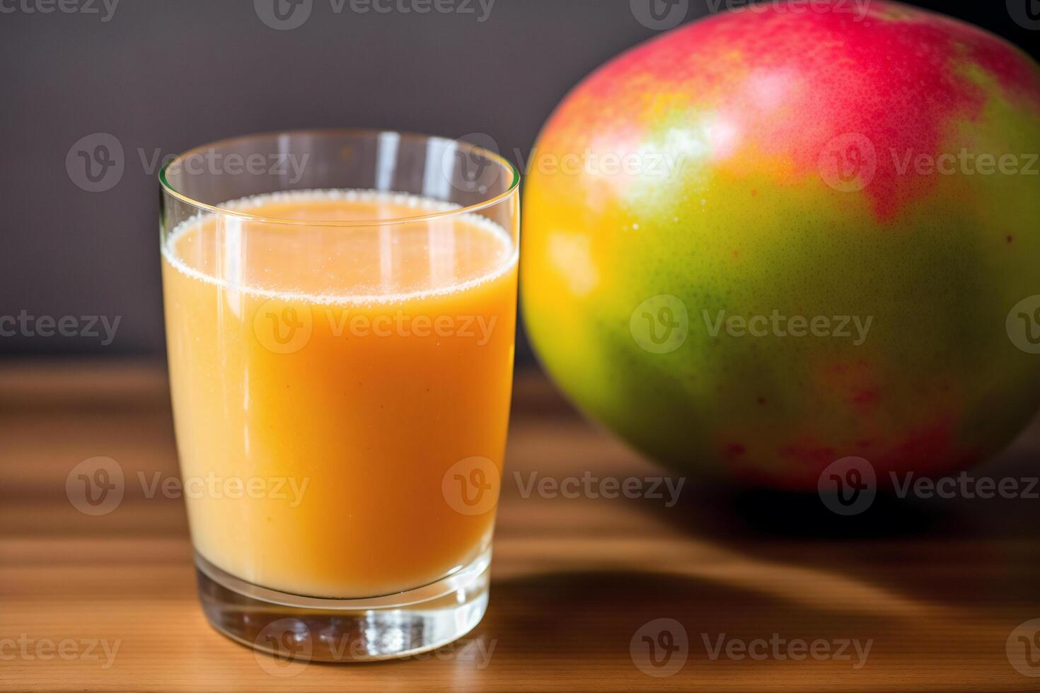 Glass of fresh mango juice on wooden table, closeup. Healthy food concept. photo