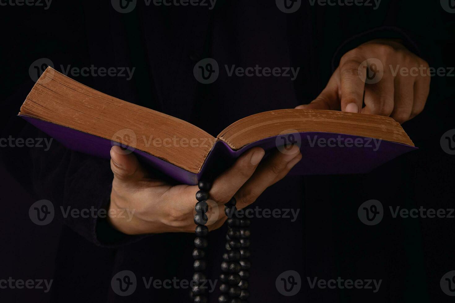 Spirituality, Religion and Hope Concept. Person Praying by Holy Bible and Bead. Symbol of Humility, Supplication, Believe and Faith for Christian People. Dark Tone. Cropped and Selective focus photo