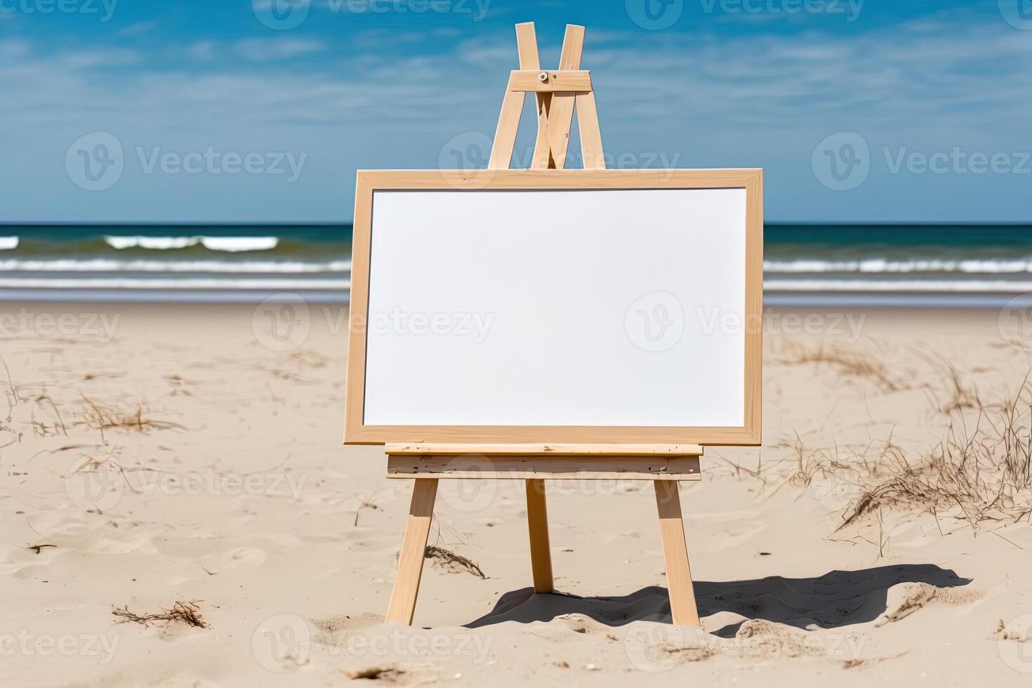 White blank artist frame on a small wooden easel on summer sea beach background with copy space. Advertising mockup artboard for pictures or artwork. Painting frame template banner. photo