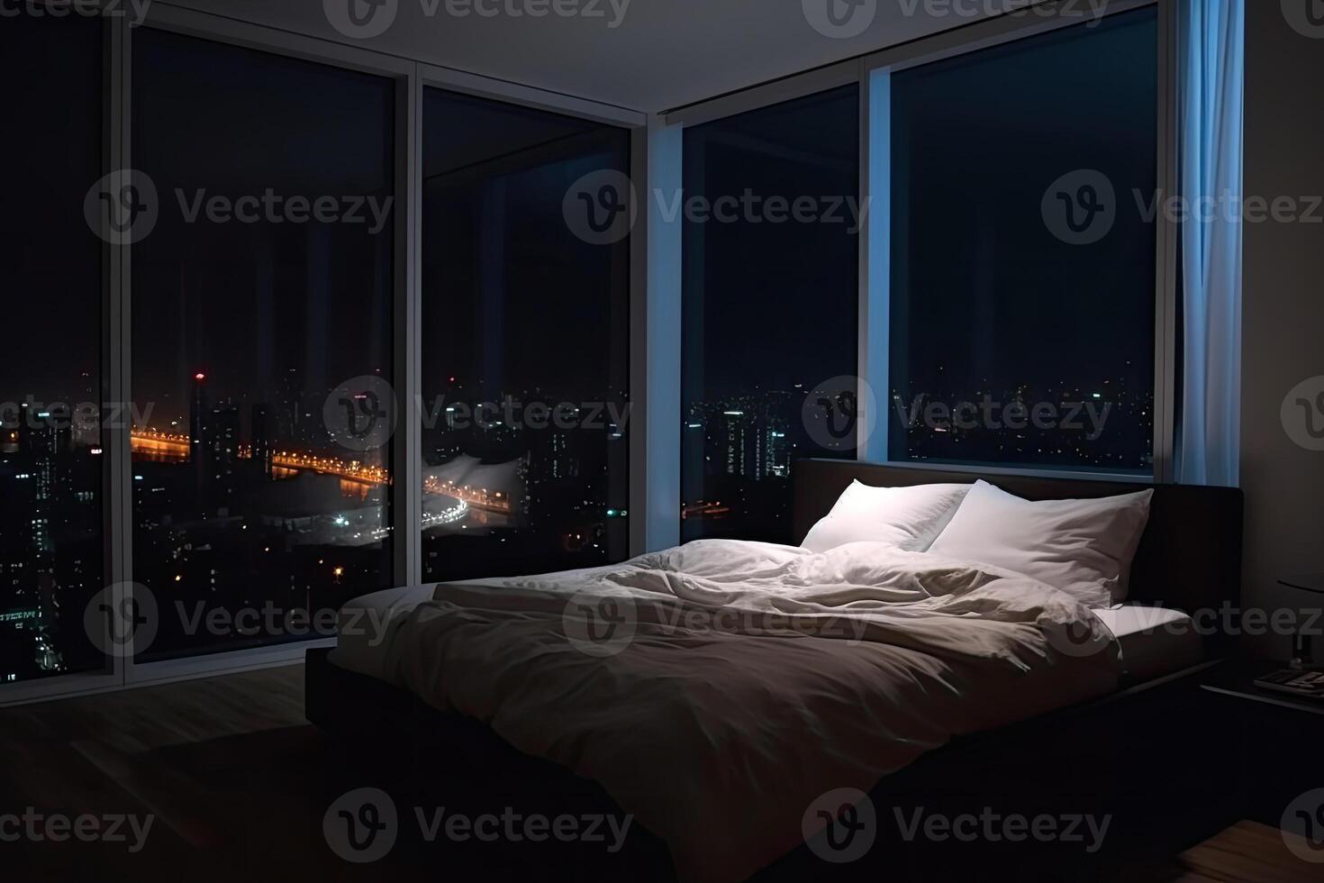 Large bed in living room with night city view in window. photo