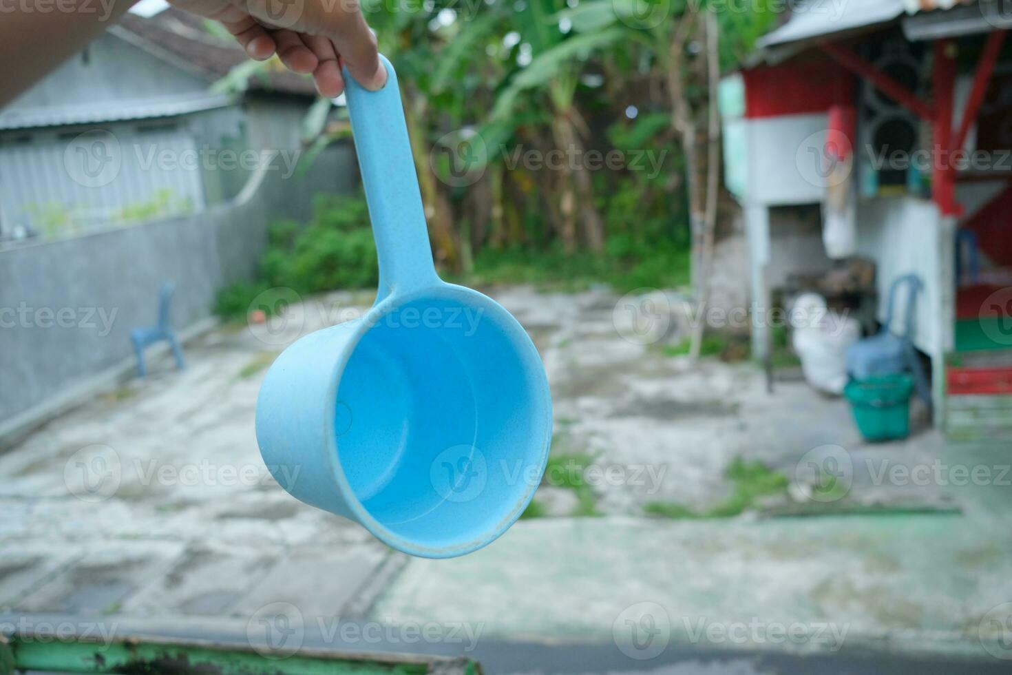 photo of blue water dipper in hand