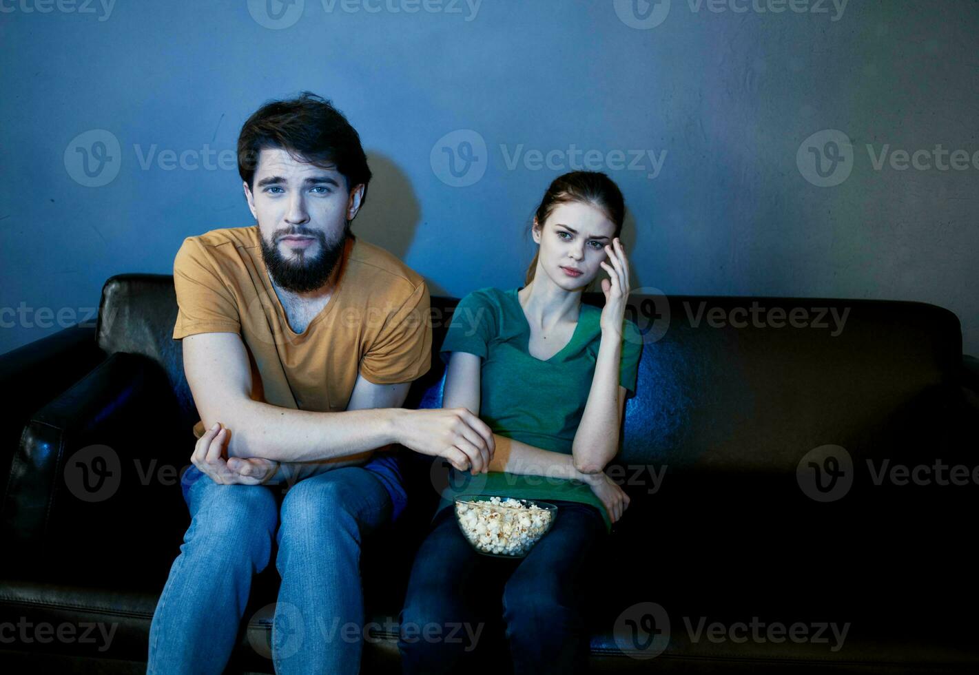 hermoso hombre y joven mujer en sofá adentro acecho televisión en el noche foto