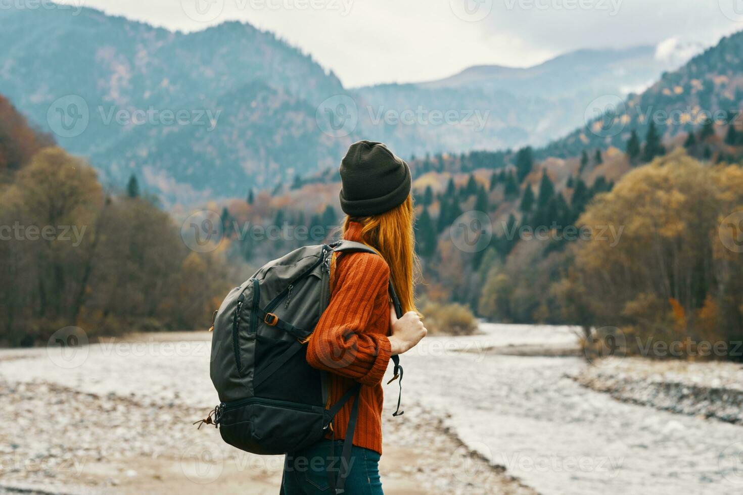 woman hiker with a backpack rest in the mountains in nature near the river photo