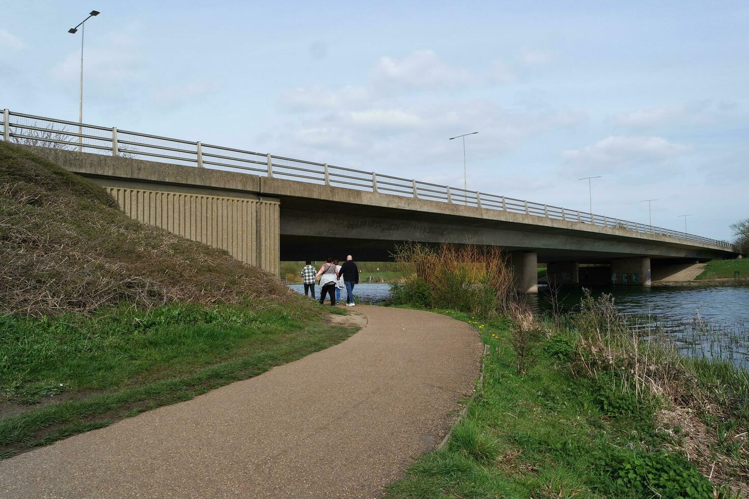 Low Angle View of Willen Lake Park with Local and Tourist Public Enjoying the Beauty of Lake and Park by Walking Around with Their Families. Footage Was Captured on 09-April-2023 at Milton Keynes UK photo