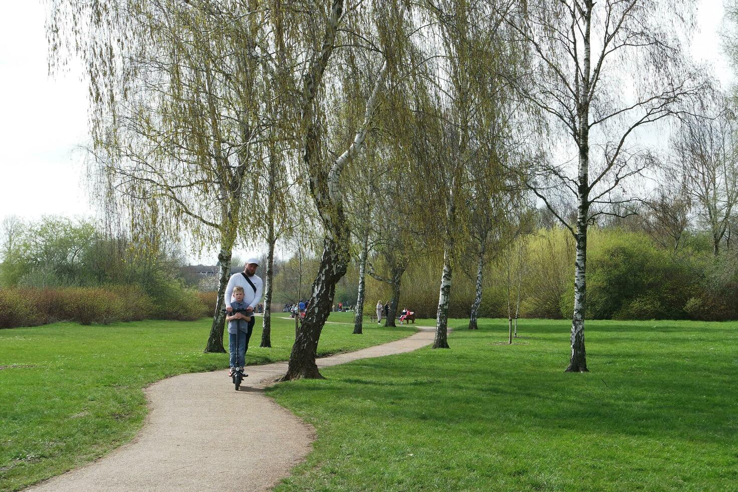 Low Angle View of Willen Lake Park with Local and Tourist Public Enjoying the Beauty of Lake and Park by Walking Around with Their Families. Footage Was Captured on 09-April-2023 at Milton Keynes UK photo