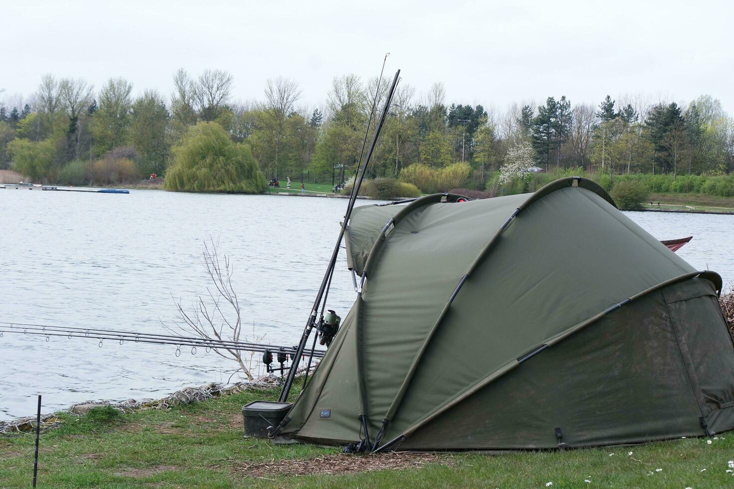 Low Angle View of Willen Lake Park with Local and Tourist Public Enjoying the Beauty of Lake and Park by Walking Around with Their Families. Footage Was Captured on 09-April-2023 at Milton Keynes UK photo