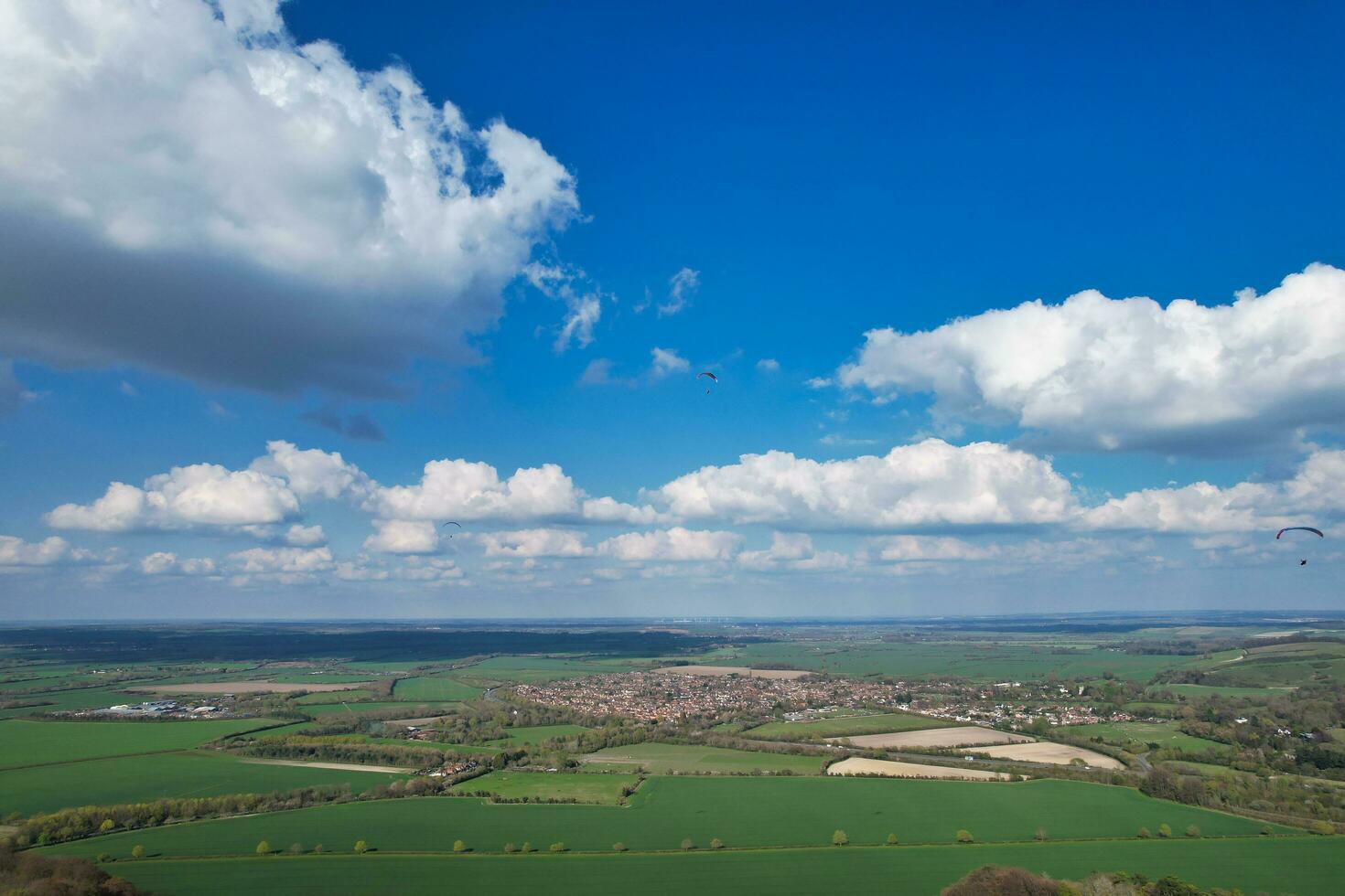 Aerial View of British Countryside and Paragliders while they are Flying High in the Sky. Drone's Camera Footage. photo