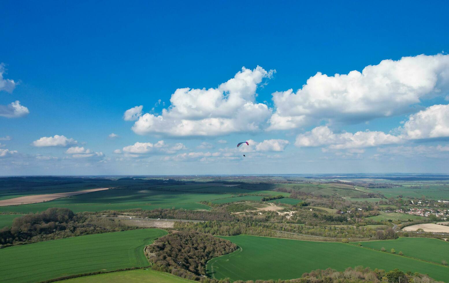Aerial View of British Countryside and Paragliders while they are Flying High in the Sky. Drone's Camera Footage. photo