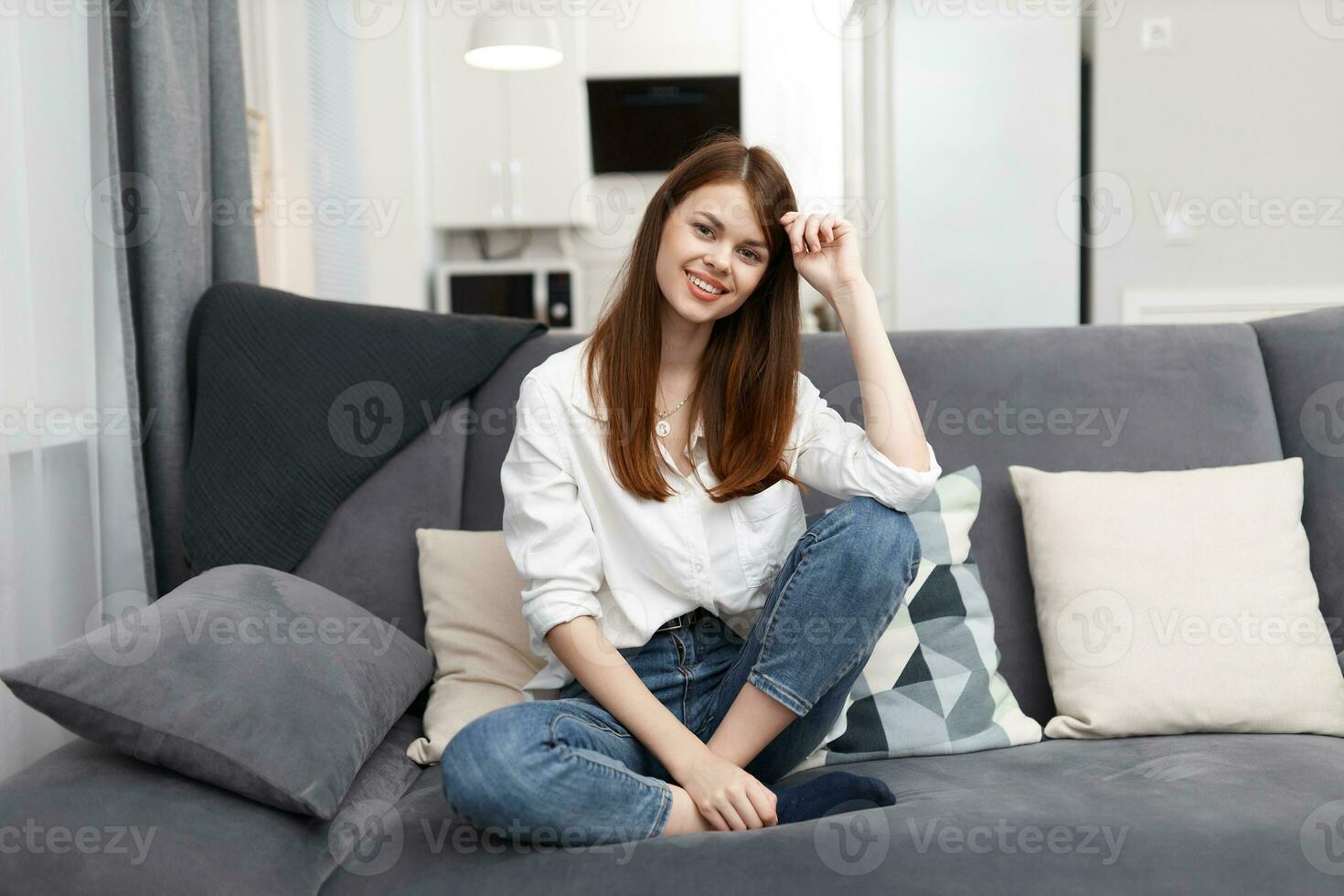 woman sitting on the sofa with pillows comfortable apartment photo