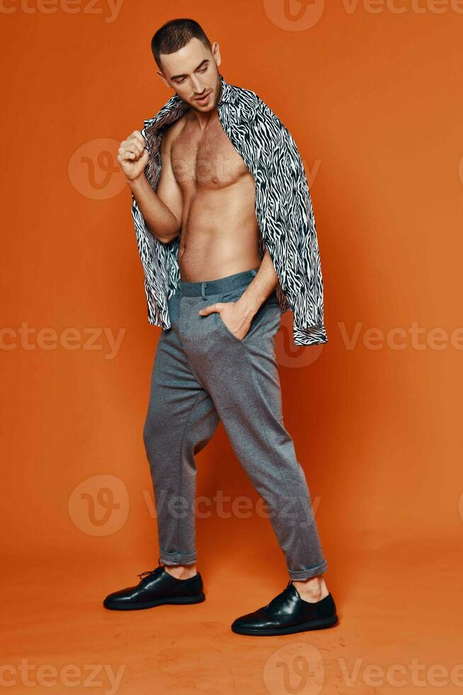 handsome man in shirt nude torso posing fashion orange background photo