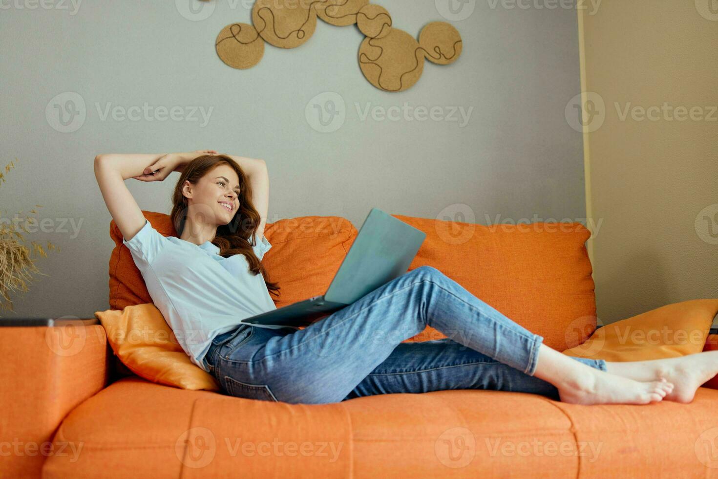 smiling woman laptop on my lap at home on the sofa entertainment technologies photo