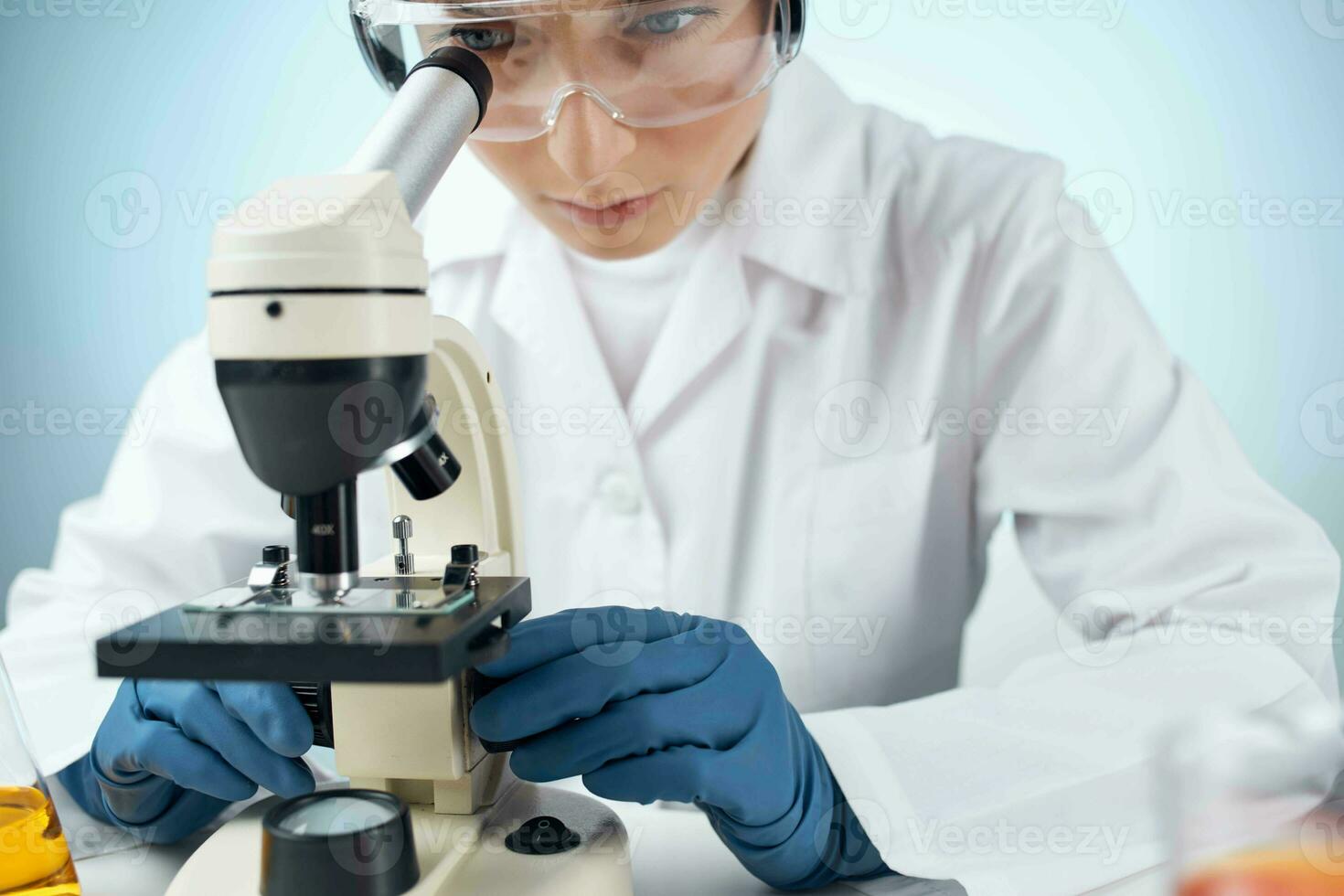 woman scientist looking through a microscope laboratory research diagnostics photo