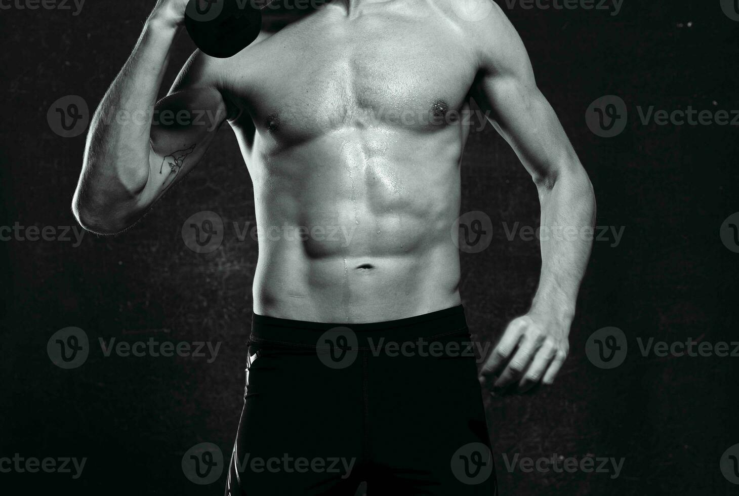 sporty man naked torso inflated body posing dark background photo