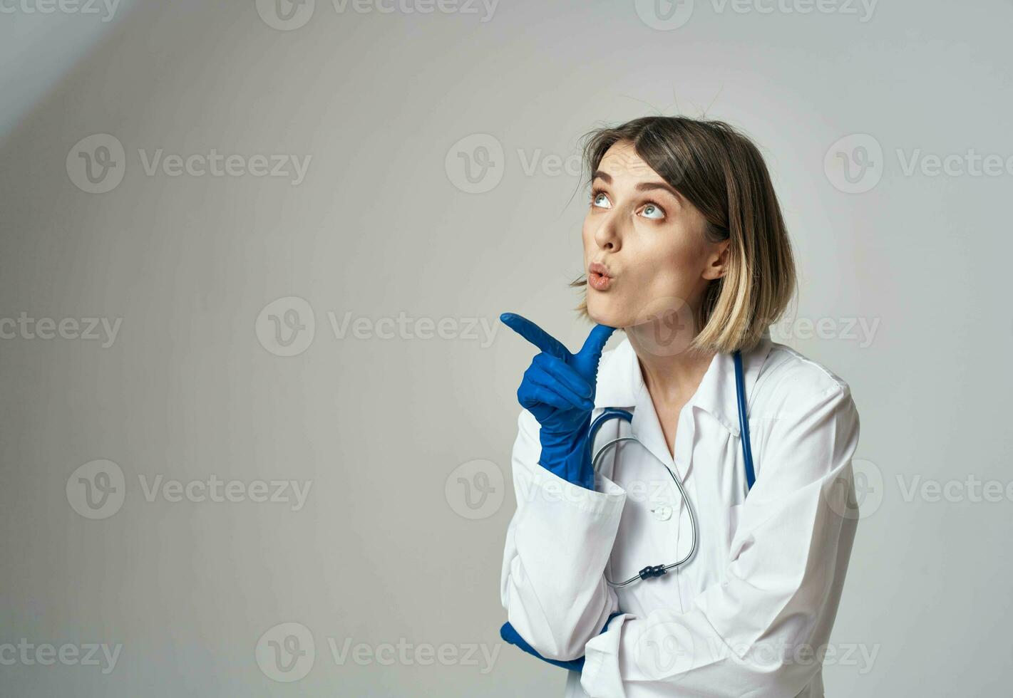 Doctor in blue medical gloves gesturing with his hands on a gray background cropped view photo