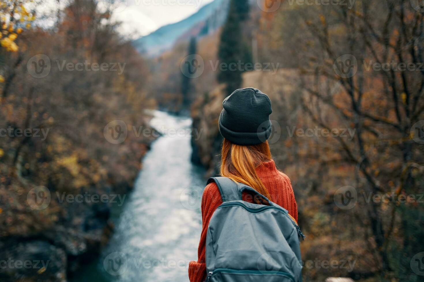 mujer con mochila en naturaleza en el puente cerca el río montañas aventuras foto