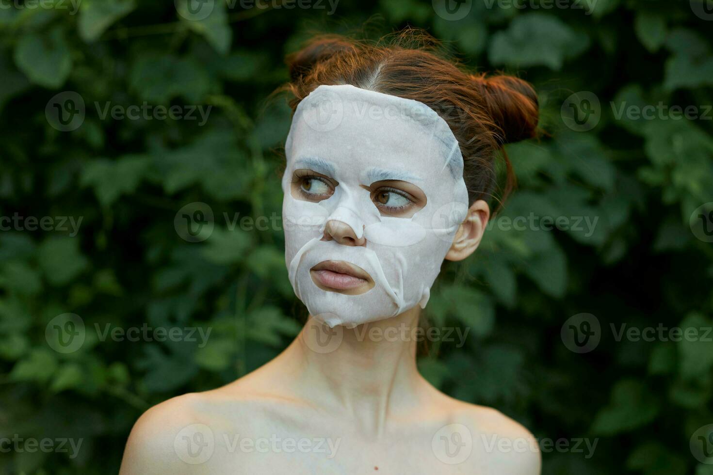 Beautiful woman cosmetic mask rejuvenation bushes in the background photo