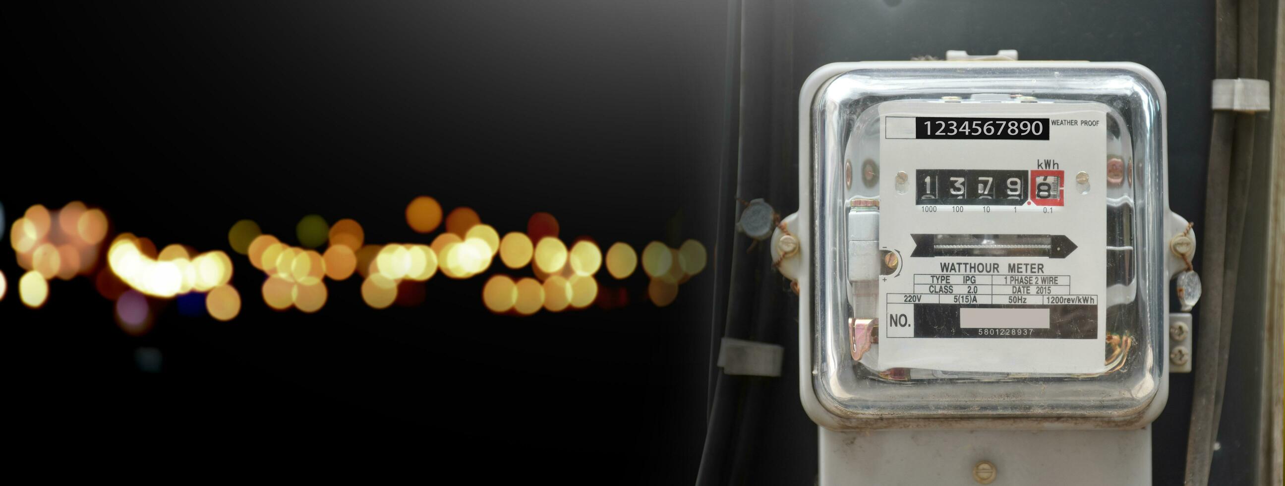 Watthour meter of electricity hung on the cement pole beside the road to monitor and measure power usage each houses in Asian countres, street light bokeh at night background, photo