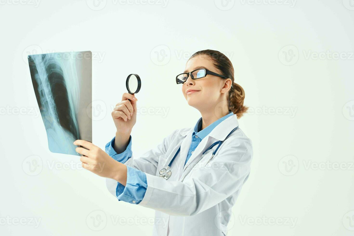 a nurse in a white coat looks at an x-ray through a magnifying glass photo