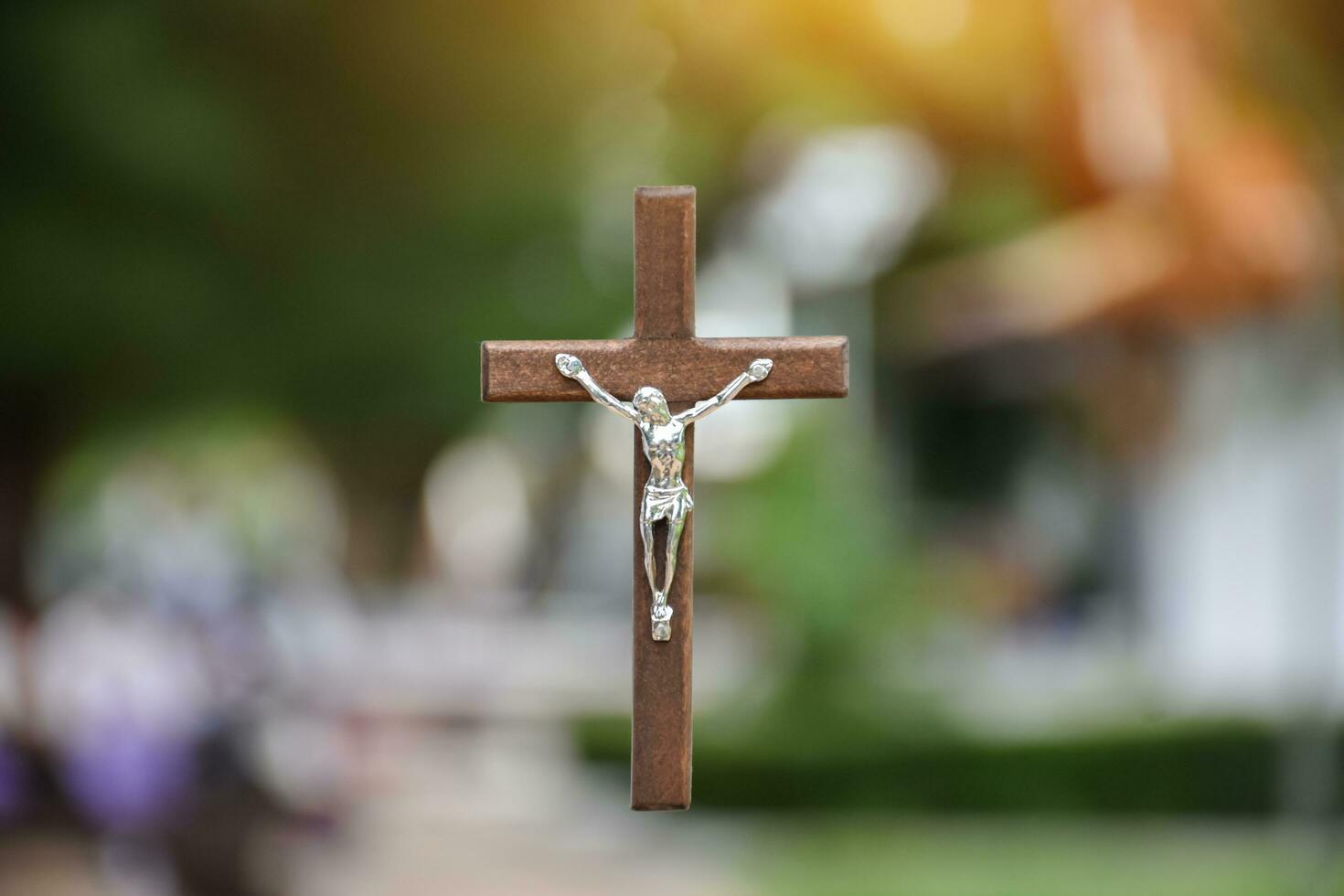 Wooden cross with blurred trees and park background, soft and selective focus. photo