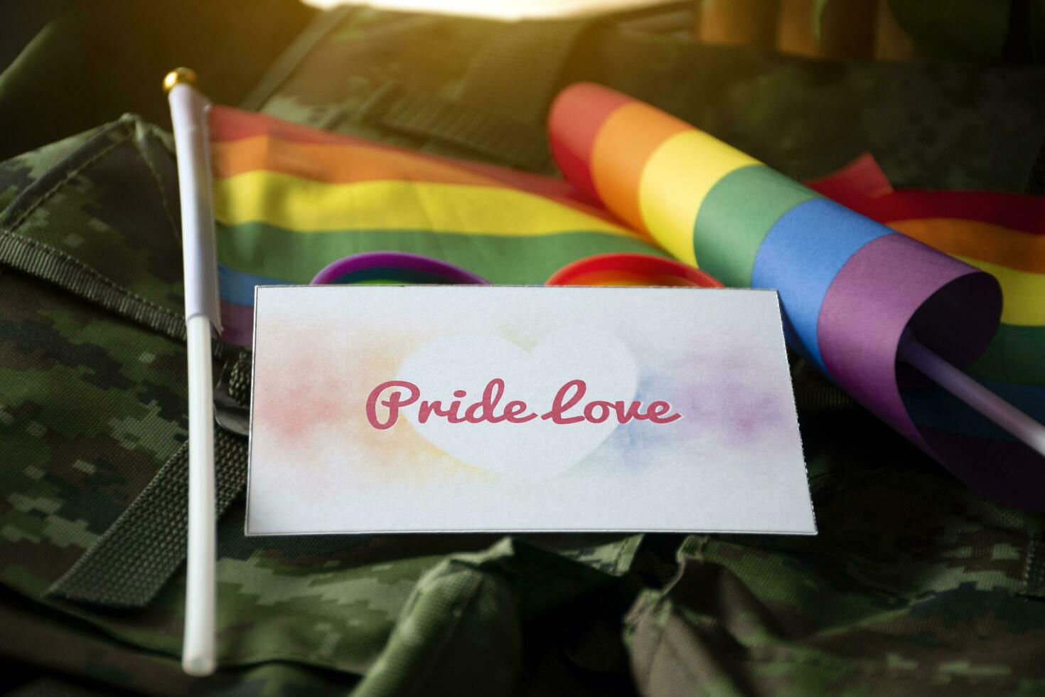 Pride Love card on camouflage backpack of soldier, concept for calling out to respect gender diversity and to invite all people to enjoy LGBTQ events around the world in pride month. photo