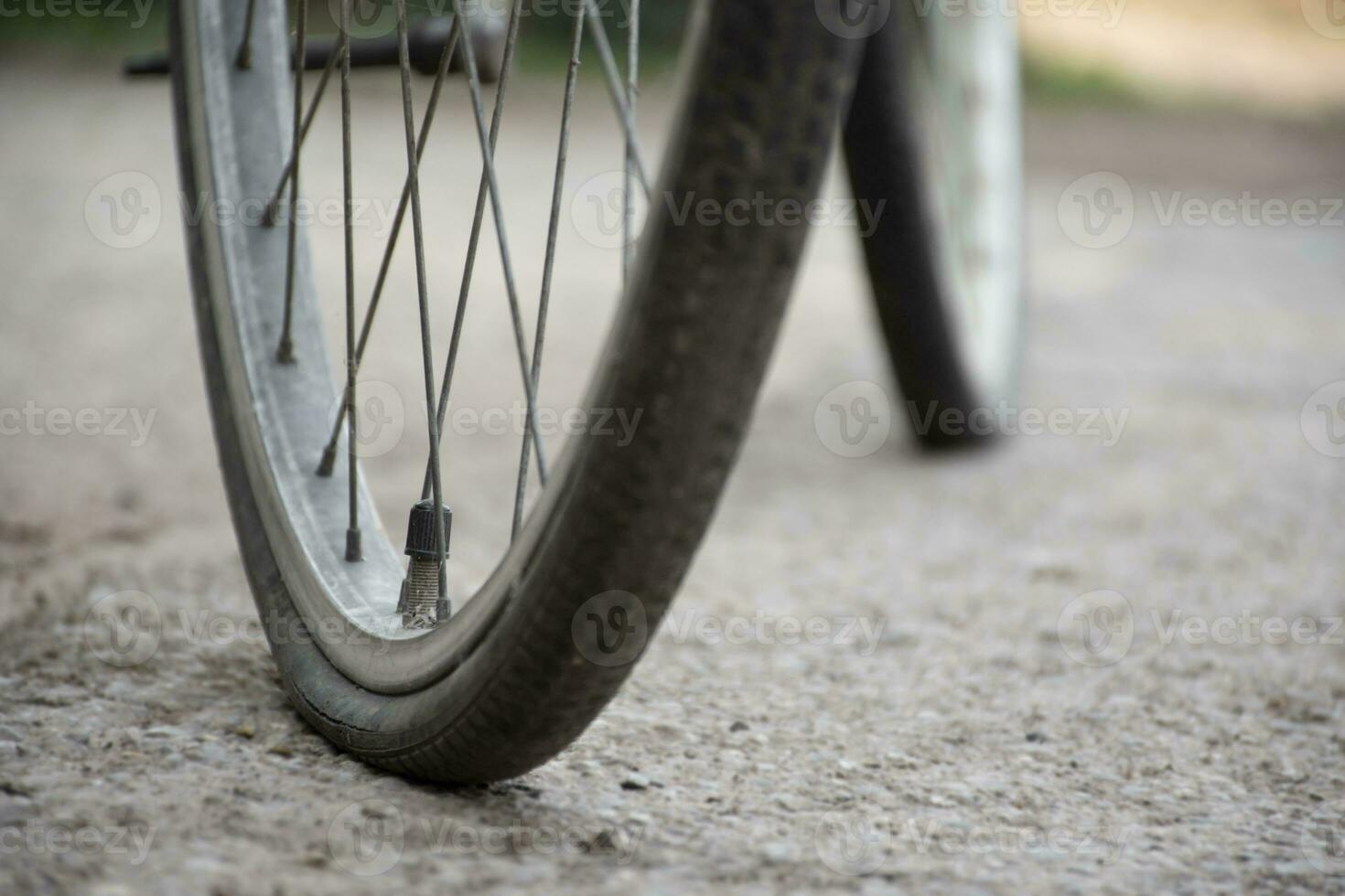 An old bike which has flat tires and parked by the urban road and waited to fix or to change the new one and to refill the air inside, soft focus. photo