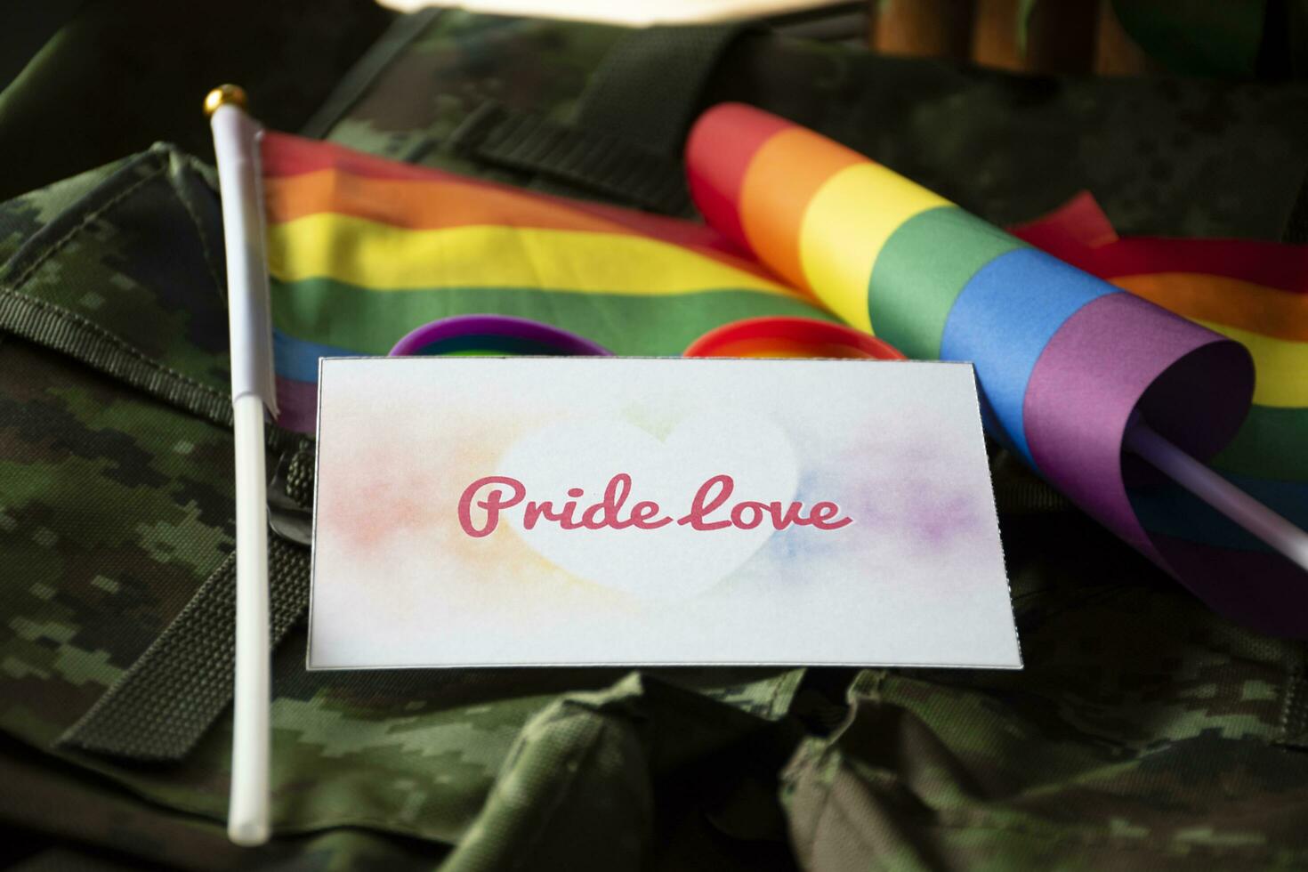 Pride Love card on camouflage backpack of soldier, concept for calling out to respect gender diversity and to invite all people to enjoy LGBTQ events around the world in pride month. photo