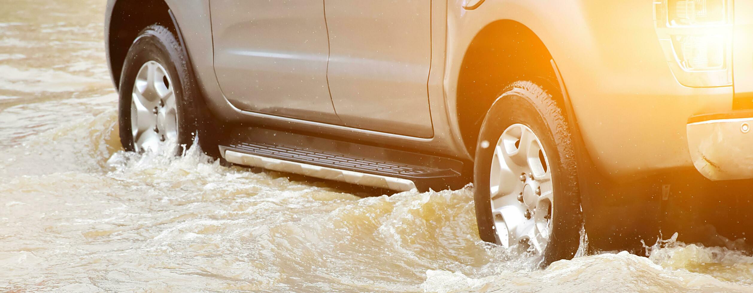 Closeup view of the rear wheel of a black pickup truck that was passing through a flood, car insurance and car fixing concept. photo