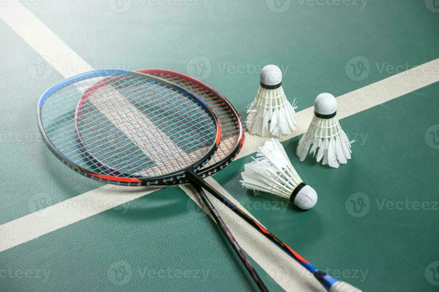 bádminton raquetas y blanco crema bádminton volantes después jugando o después juegos en verde piso en interior bádminton corte, suave enfocar, concepto para bádminton amantes alrededor el mundo. foto