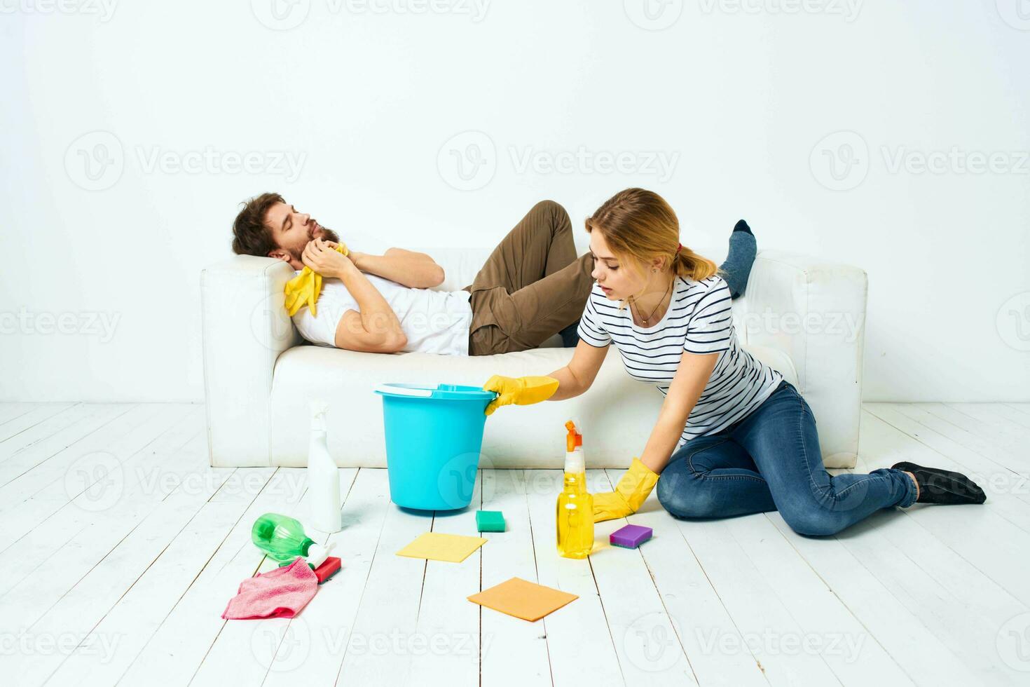 The man lies on the sofa woman washes the floors providing services interior housework photo