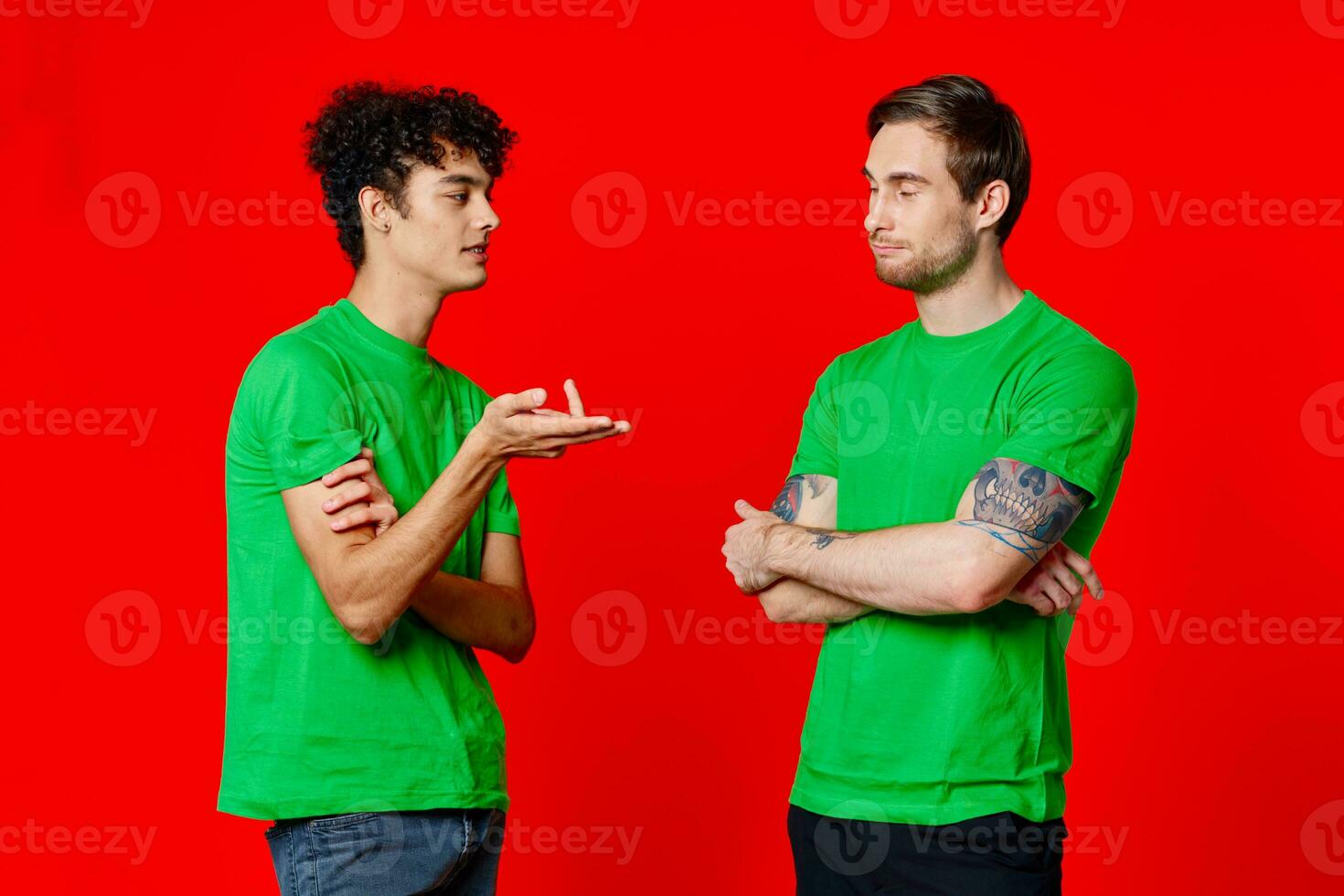 two friends in green t-shirts are standing side by side communication positive red background photo
