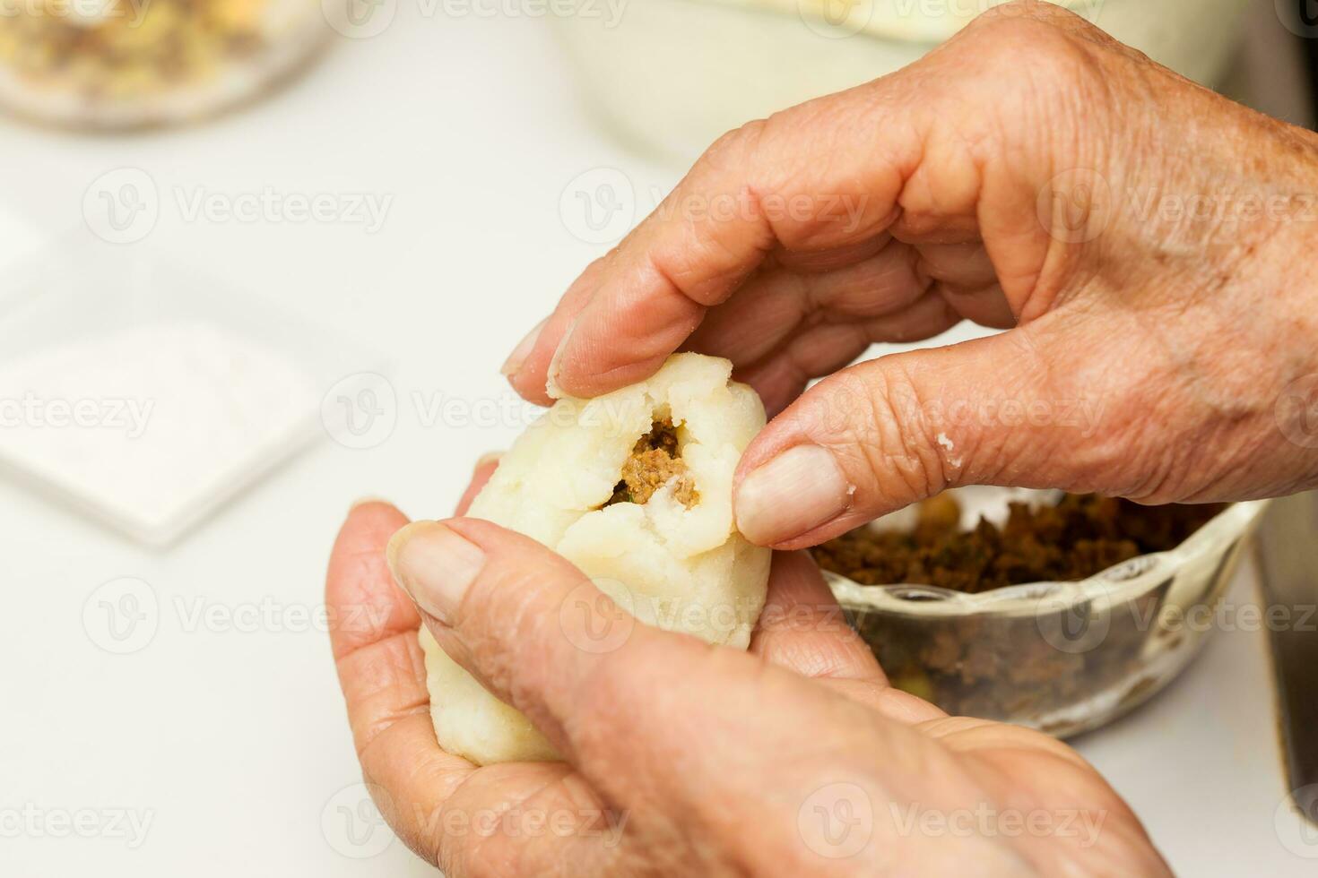 Preparation steps of traditional Colombian dish called stuffed potatoes. Stuffing the mashed potatoes dough for the stuffed potatoes photo