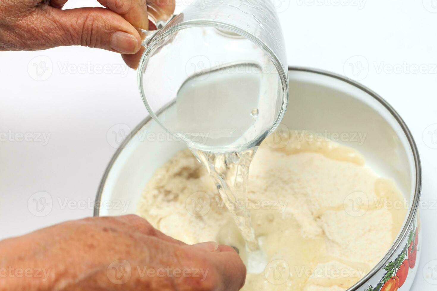 Colombian arepa dough preparation. Add salted warm water to the cornmeal photo