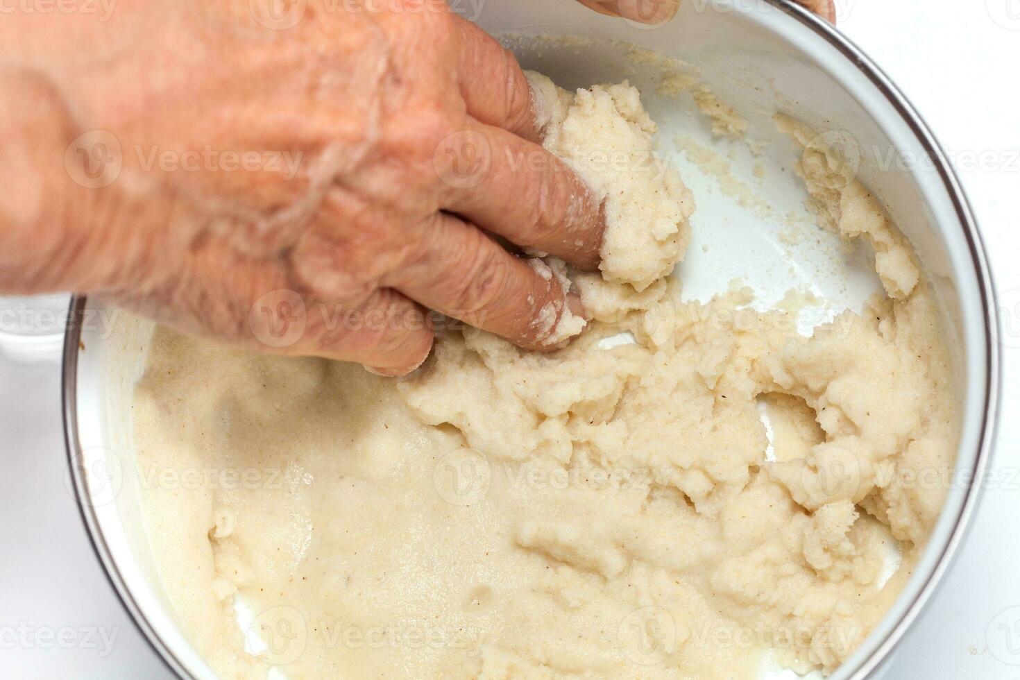 Colombian arepa dough preparation. Knead by hand the cornmeal with water photo