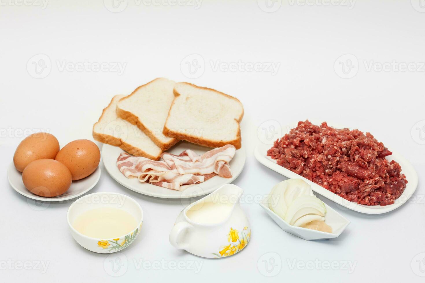 Preparation of a baked egg and vegetables stuffed meatloaf covered with bacon. Meat roll photo