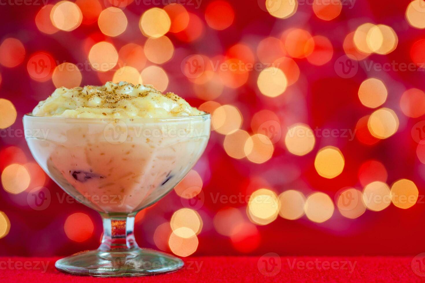 tradicional Colombiana postre hecho de arroz y Leche llamado arroz Delaware leche en un Navidad rojo antecedentes foto