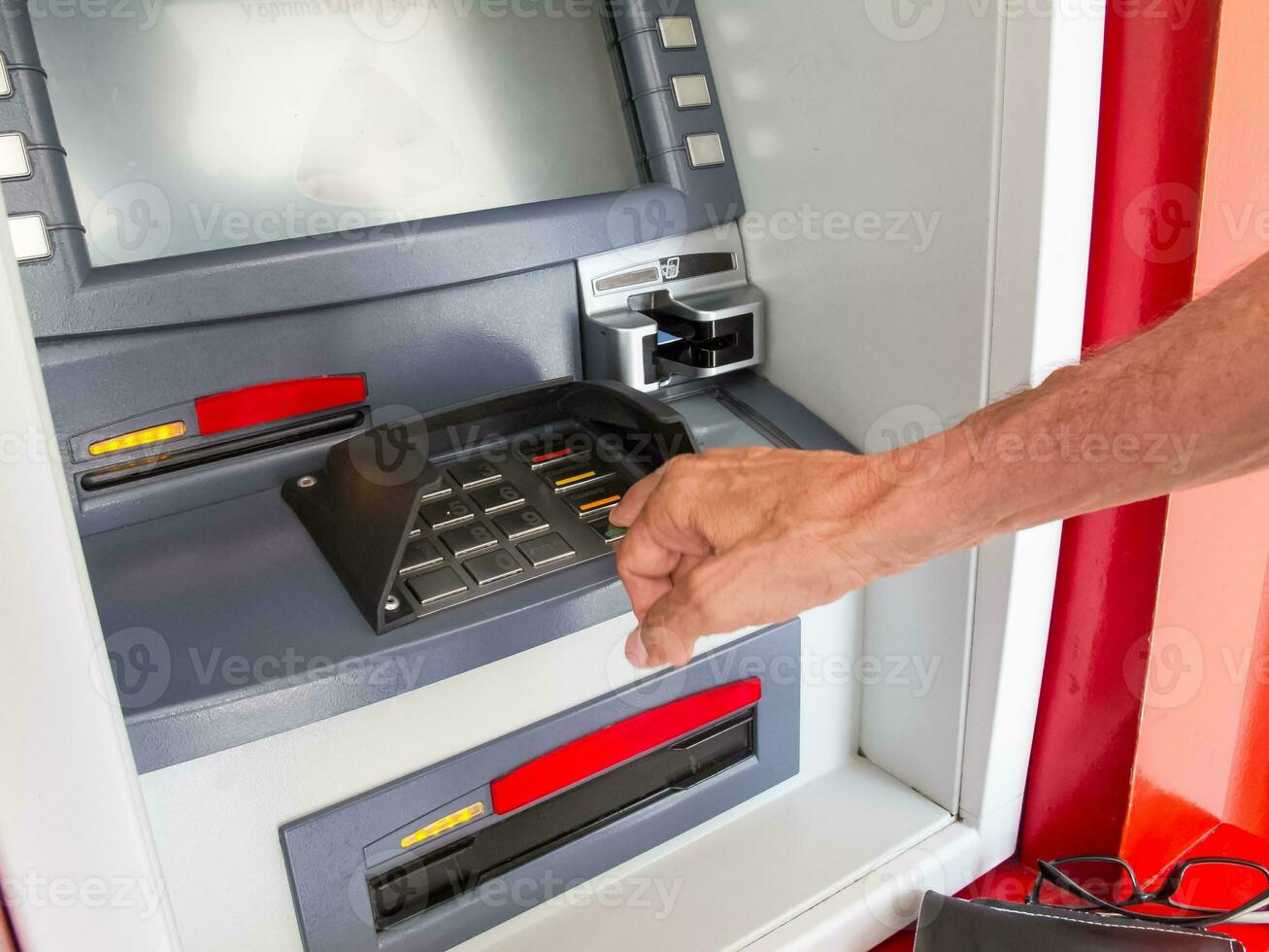 cerca arriba de un hombre retirarse dinero desde un Cajero automático foto