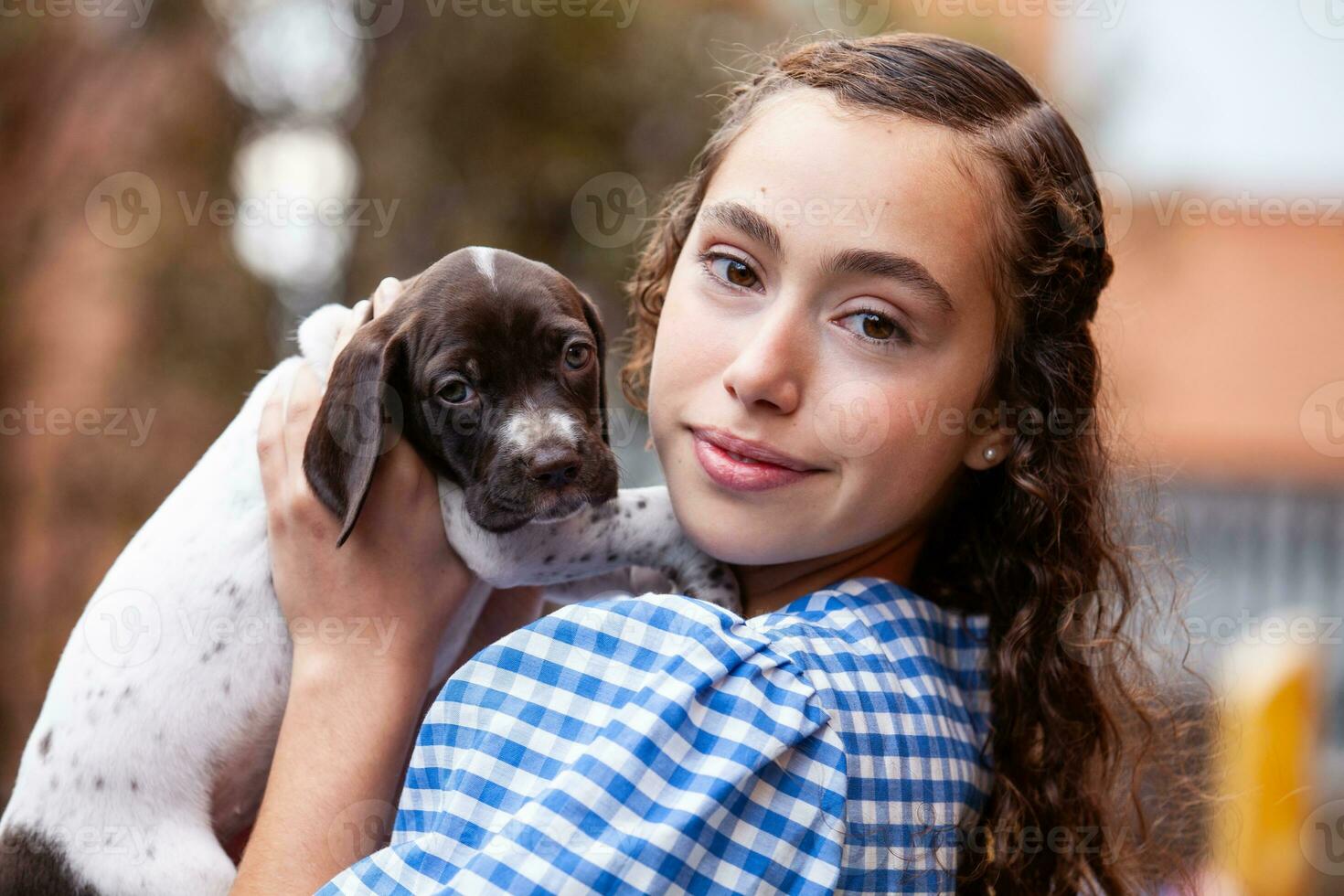 Beautiful young girl having fun with her small French Braque puppy photo