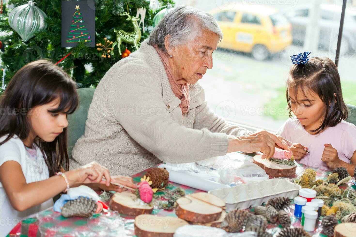 Grandmother teaching her granddaughters how to make christmas Nativity crafts - Real family photo