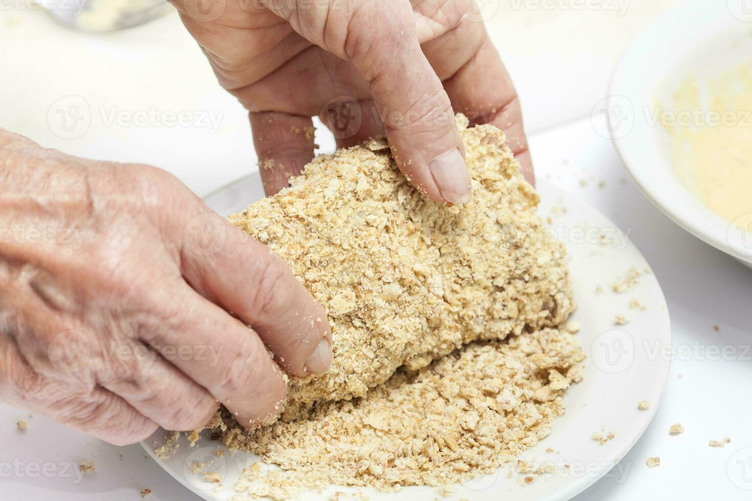 Breading a cordon bleu. Adding crumbled cracker photo