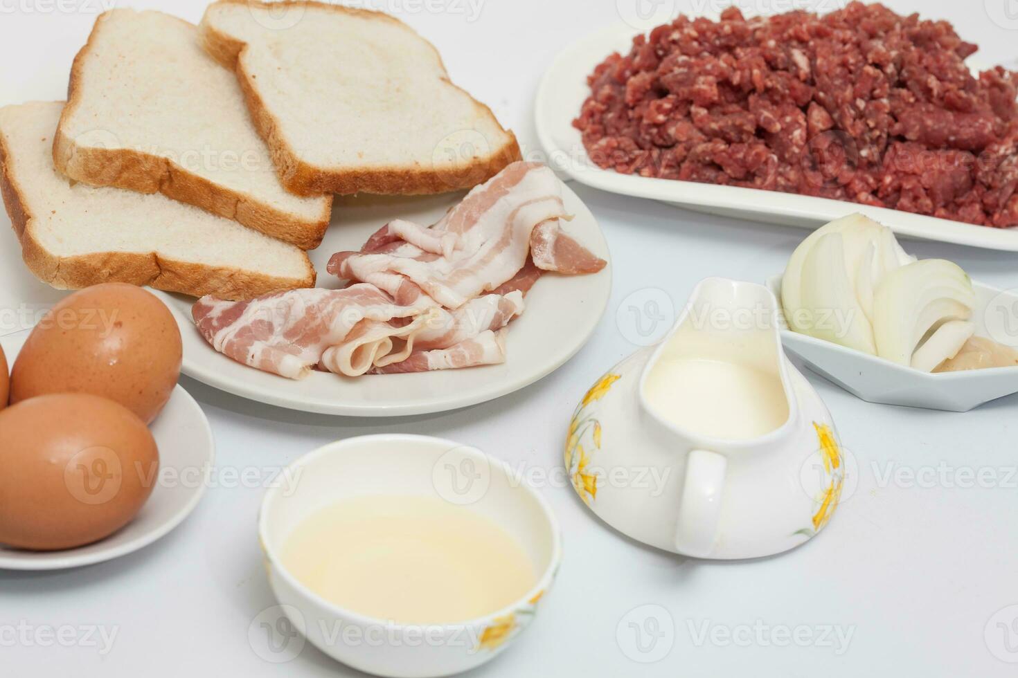 Preparation of a baked egg and vegetables stuffed meatloaf covered with bacon. Meat roll photo