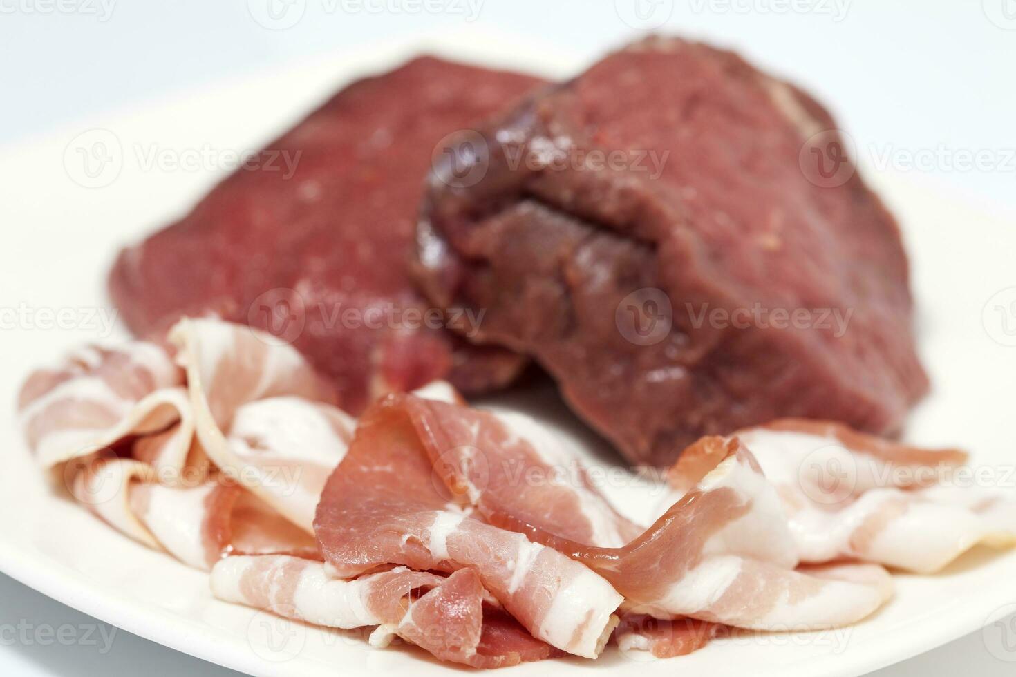 Raw medallions of beef tenderloin and pork bacon. Filet mignon preparation. photo