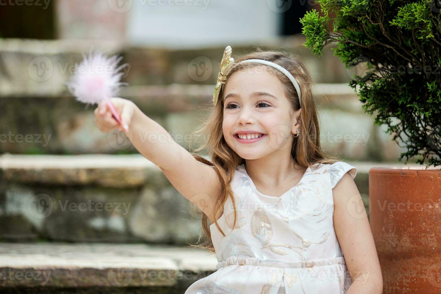 Little blonde girl writing outdoors photo