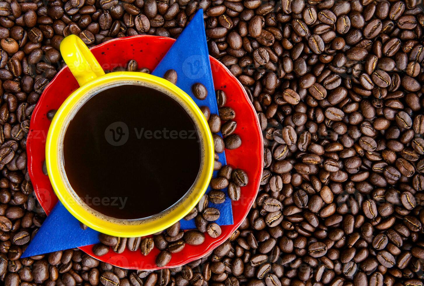 Cup of Colombian coffee and the colors of the Colombian flag over a background of roasted coffee beans photo