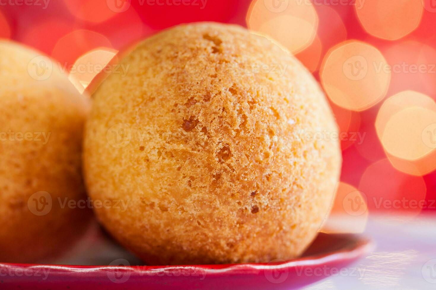 Traditional Colombian bunuelos. Deep Fried Cheese Bread on christmas red background photo