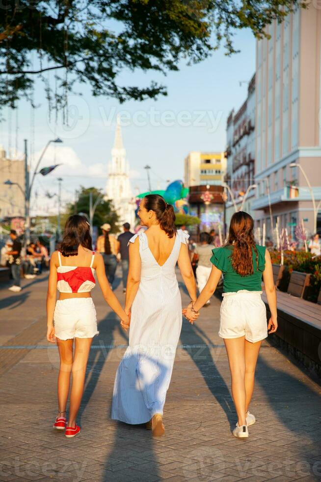 Tourists walking along the  Cali River Boulevard with La Ermita church on background in the city of Cali in Colombia photo