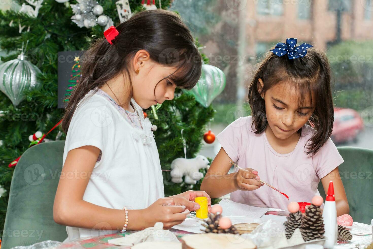 Two little sisters having fun while making christmas Nativity crafts with at home - Real family photo