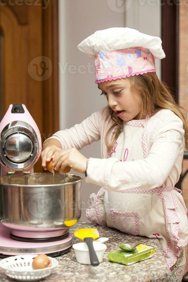 Beautiful blonde girl baking cupcakes and having fun at home photo